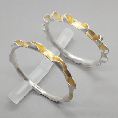 Two silver and gold anticlastic bangles